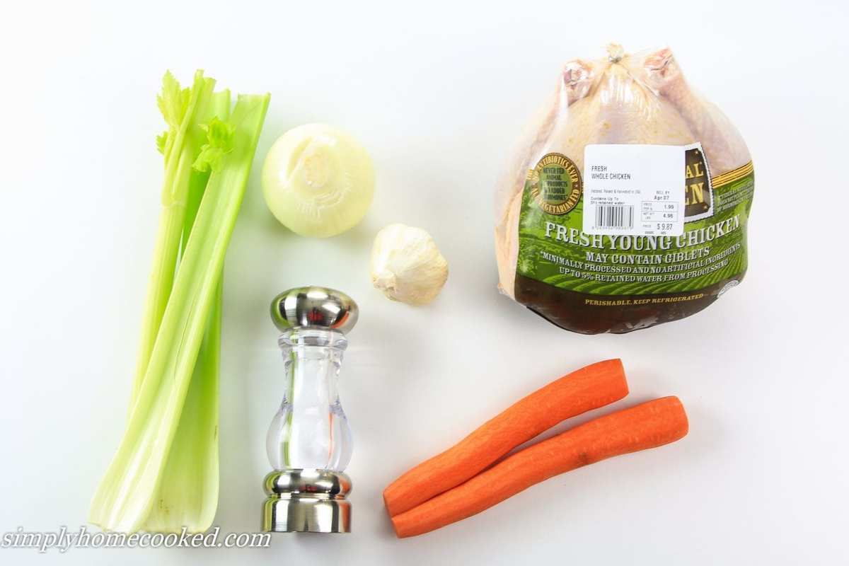Easy fuss free chicken broth recipe that will make a good soup into a great soup! #chickenbroth #homemadebroth #chickenstock #bonebroth an overhead image of ingredients for chicken broth in a white background