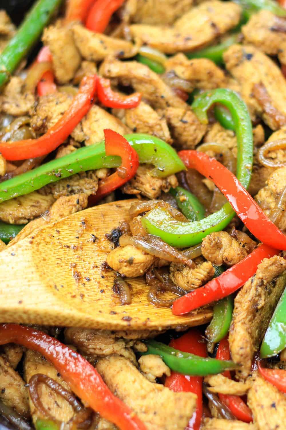 chicken and red and green bell peppers in a cast iron pan