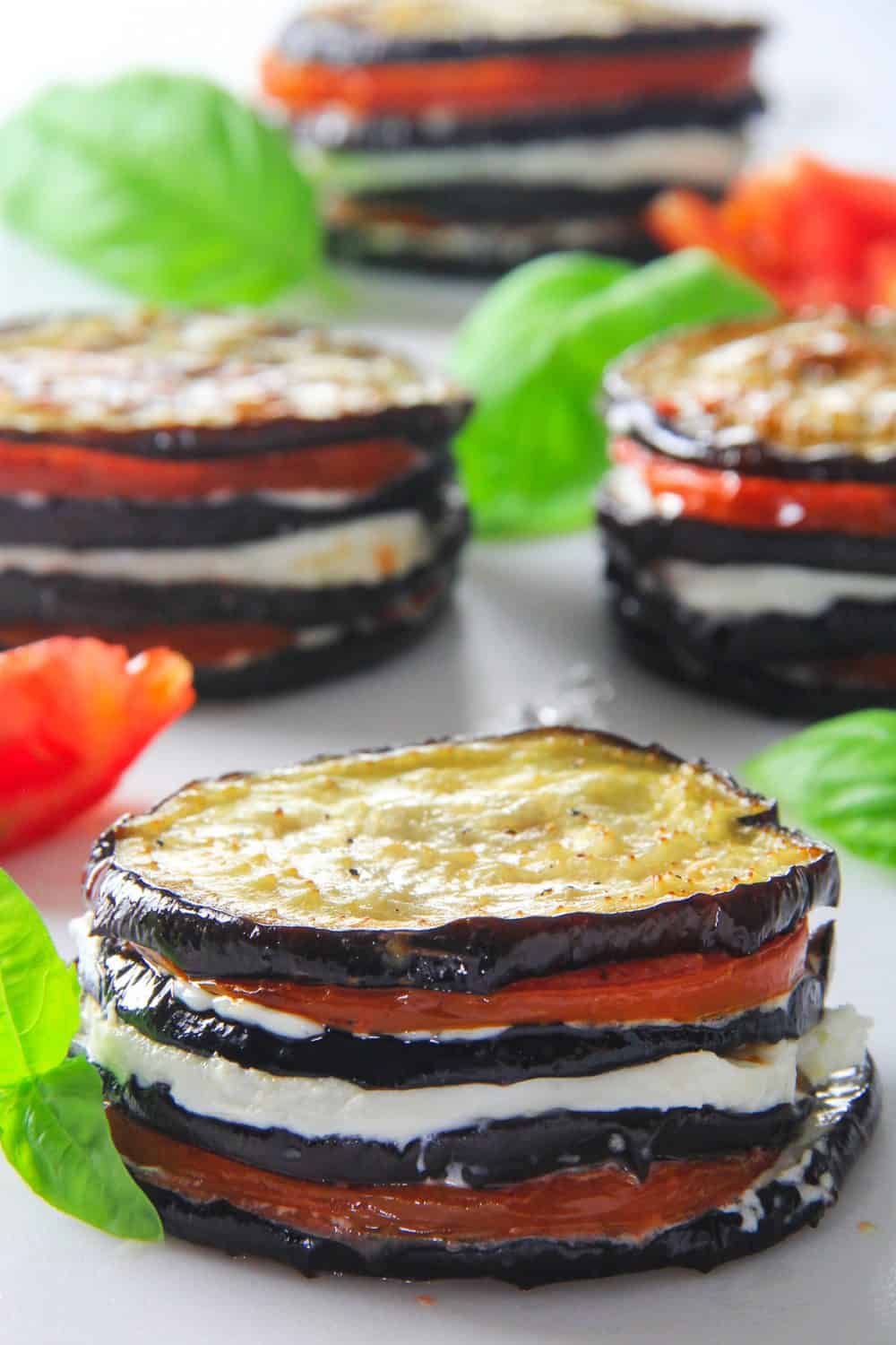 eggplant napoleon stacked with slices eggplant, sliced tomato, and sliced mozzarella cheese. with basil beside it