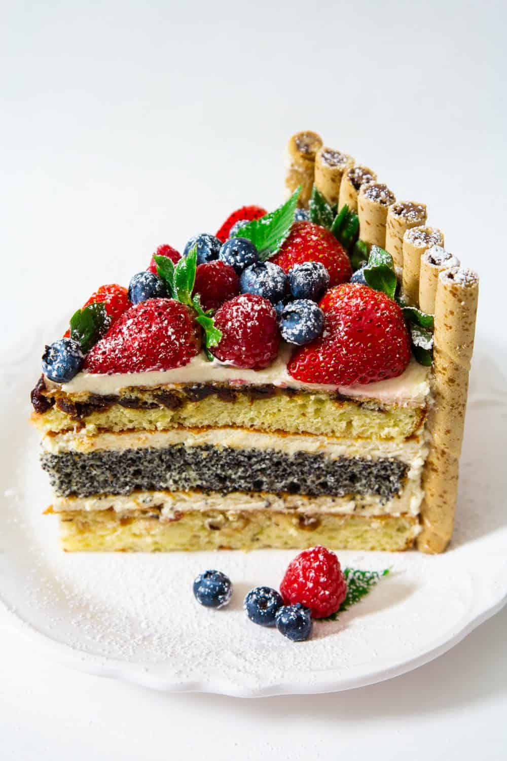 Decadent layers of hazelnuts, poppyseed, and cherry cake with creamy dulce de leche frosting. This Russian Royal cake recipe is the ultimate holiday cake! #royalcake #russiancake #korolevskytort #korolevsky #russianlayercake A slice of Russian Royal cake that shows off the multiple cake layers