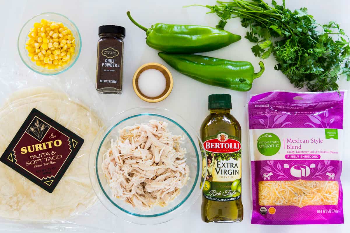 These easy chicken quesadillas are loaded with Mexican cheese, hatch chilies, and juicy rotisserie chicken. Its the perfect recipe for busy weeknights! #chickenquesadillas quesadilla #mexicanrecipe #mexicanfood #30minutemeal overhead shot of ingredients needed to make easy chicken quesadillas