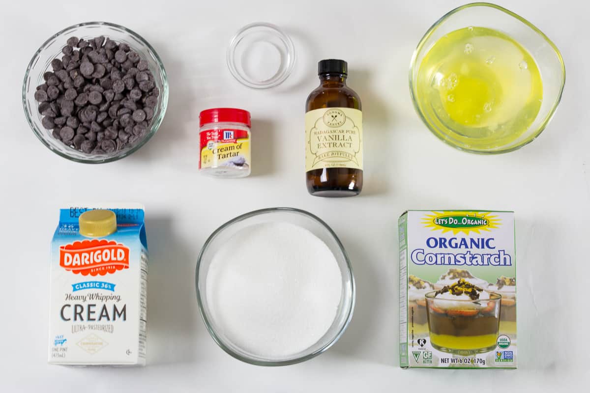 These meringue cookies are topped with rich chocolate cream, chopped hazelnuts, and fresh berries. It's a delicate dessert that everyone loves! #meringuecookies #meringuebites #russiandessert #meringuedessert an overhead photo of ingredients needed for European meringue bites on a white background