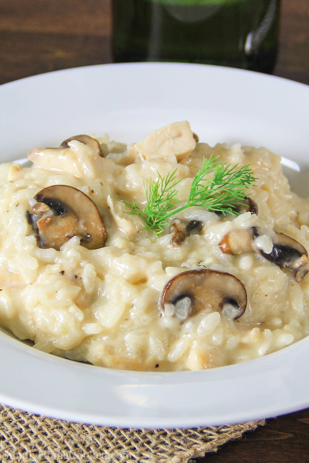 Rich and creamy risotto loaded with tender chicken and sauteed mushrooms. It's an easy and simple meal perfect for family dinner. #simpledinner #risotto #mushrooms #rice #mushroomrisotto #ricerecipe Mushroom Risotto with Chicken on a white plate