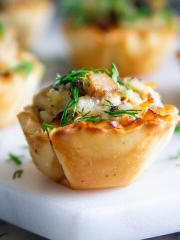 phyllo shells stuffed with chicken mushrooms and cheese and fresh dill on top