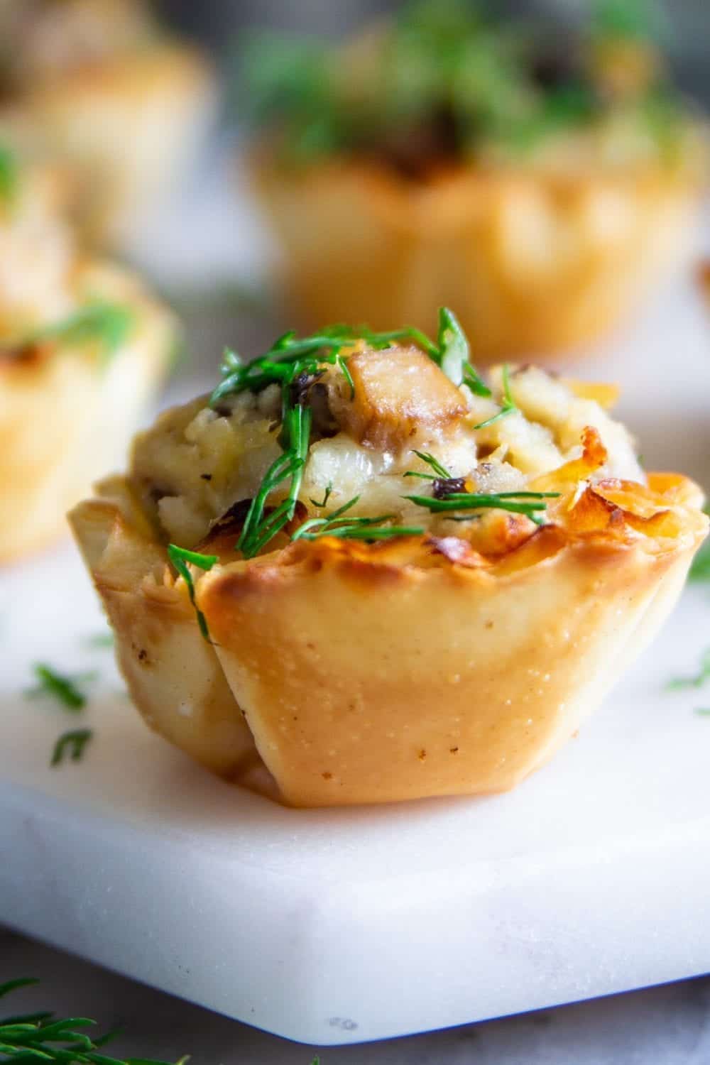 phyllo shells stuffed with chicken mushrooms and cheese and fresh dill on top