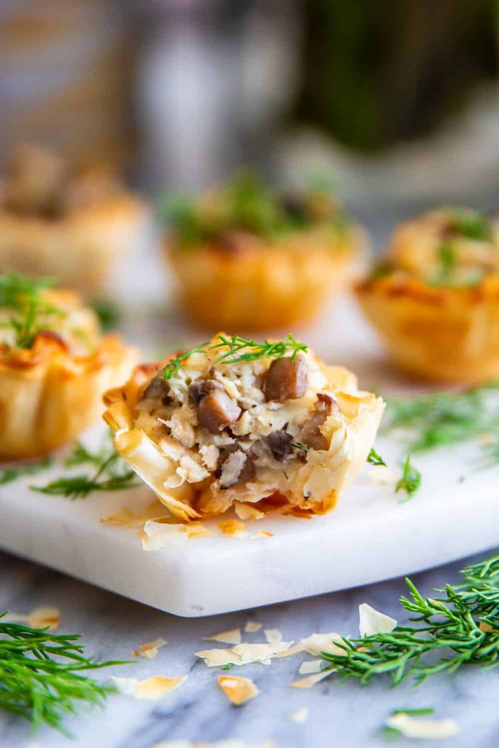 phyllo shells stuffed with chicken mushrooms and cheese and fresh dill on top