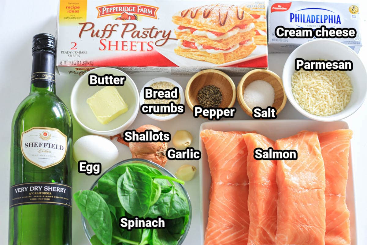 Ingredients for Salmon Wellington: salmon, puff pastry, cream cheese, Parmesan, salt, pepper, breadcrumbs, shallots, garlic, butter, egg, spinach, and white wine. 