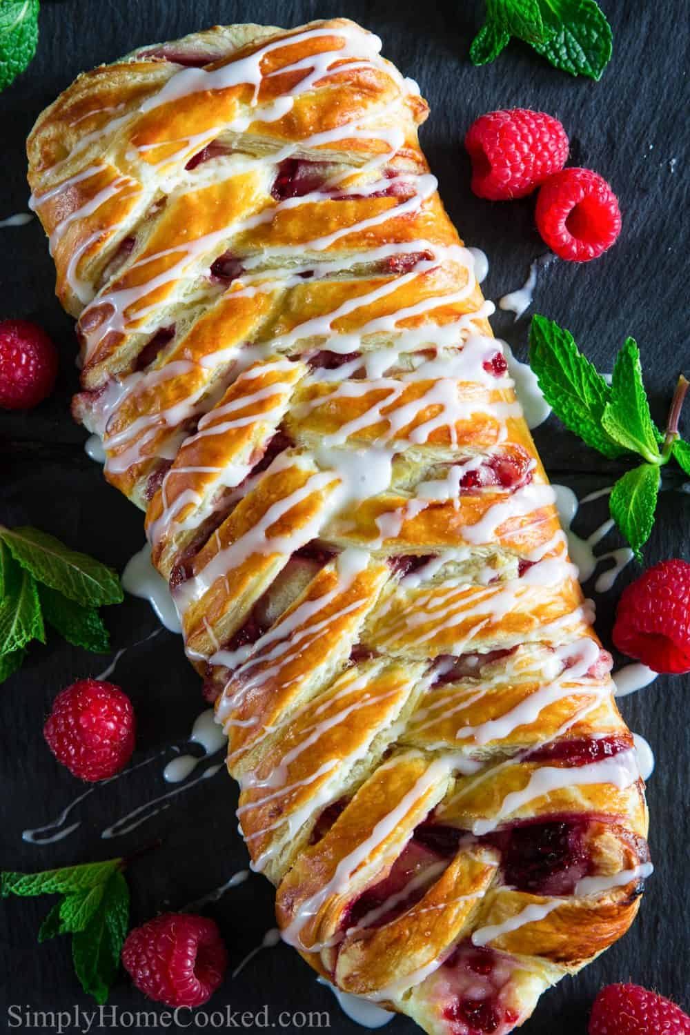 This raspberry cream cheese danish is surprisingly really easy and quick to make! This simple method of braided Danish uses puff pastry so anyone can make it! #raspberrydanish #braideddanish #creamcheesedansih #easydanish #danishrecipe Top your raspberry filled cream cheese danish with a simple powdered sugar glaze and added fresh raspberries on the side for a perfect breakfast or dessert that is a unique raspberry coffee cake idea.