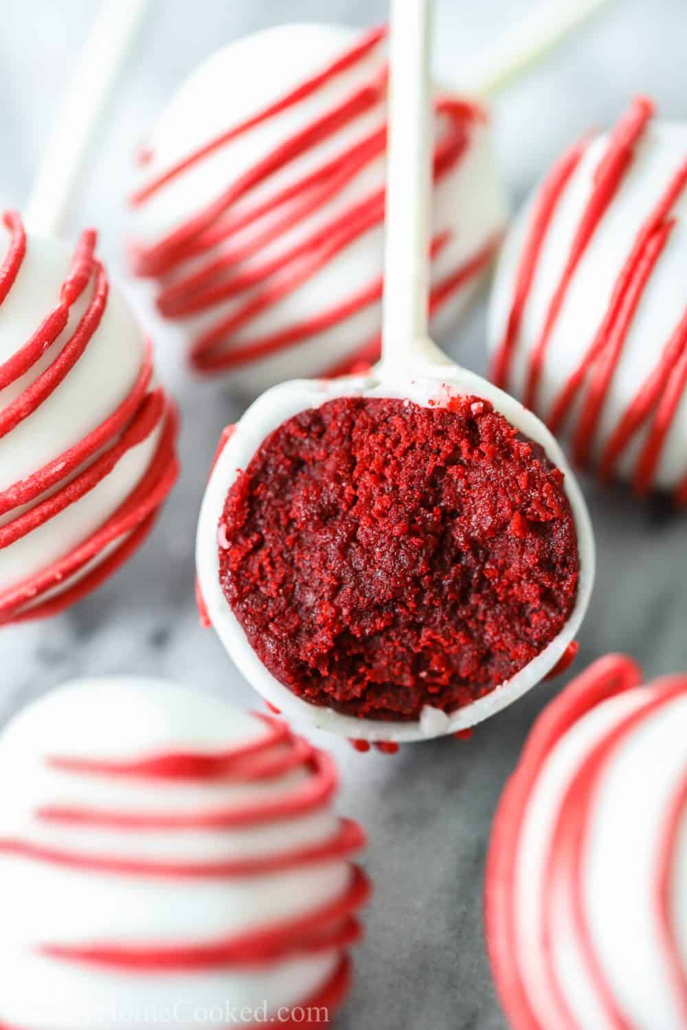 Red velvet cake pops, bite sized treats covered in white candy melts and placed on a lollipop stick