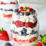 greek yogurt and berry parfait in a wine glass with mint leaves on top as garnish