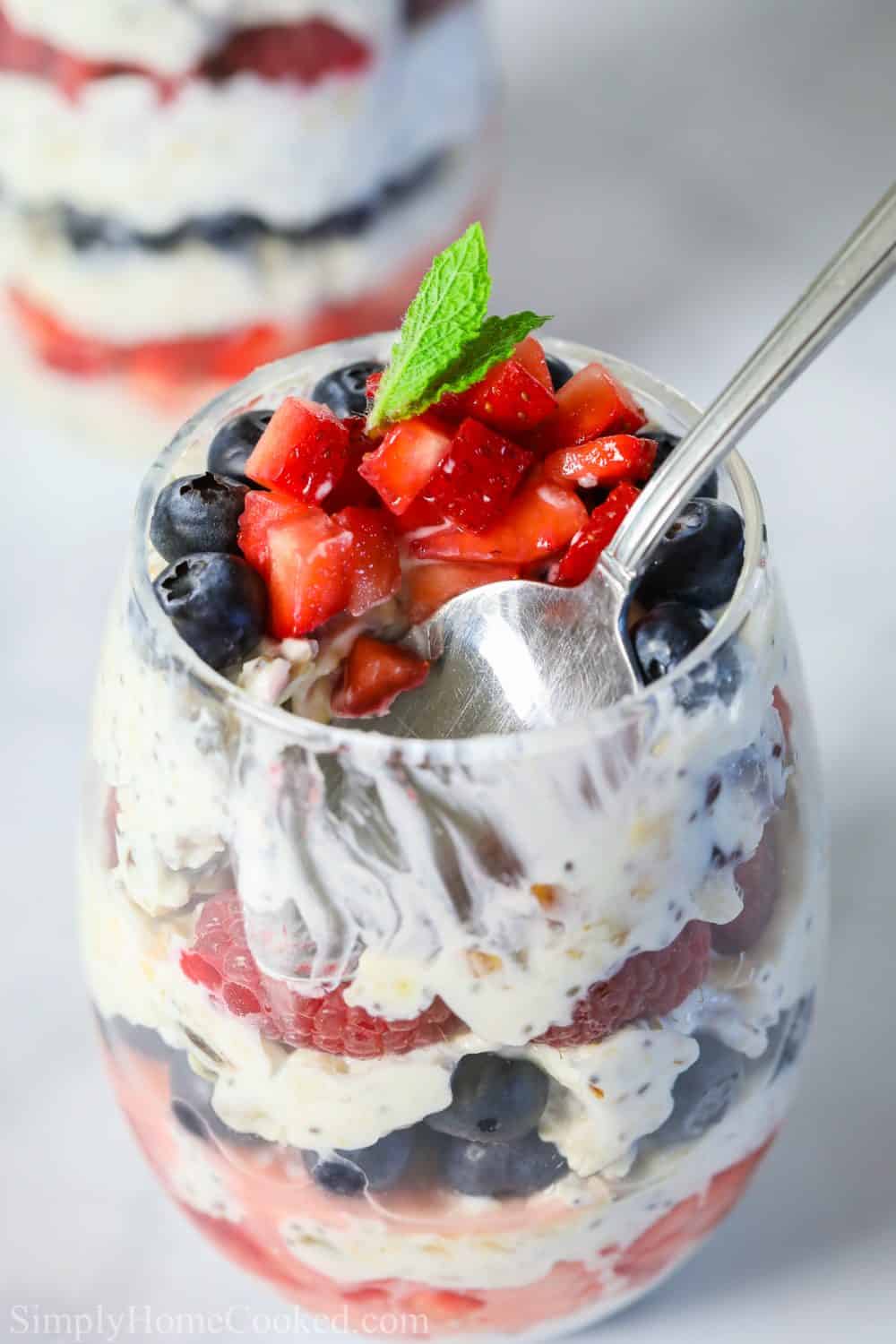 Spoon picking up a spoonful of yogurt berry and muesli parfait