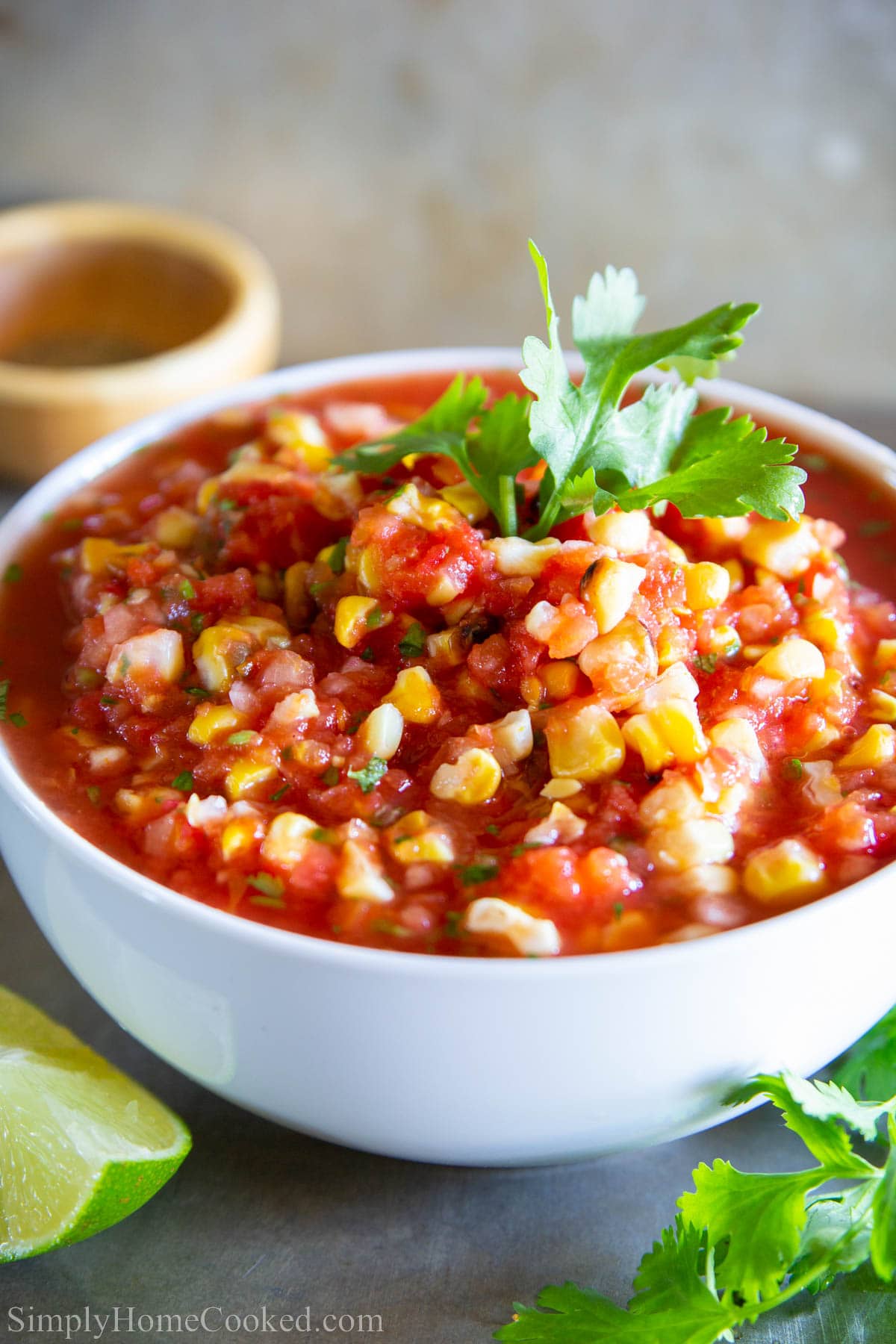 This Mexican Salsa Recipe includes delicious roasted corn to give a punch of flavor and sweetness to offset the heat of jalapenos for a perfect addition to nachos, tacos, and more! #salsa #mexicansalsa #cornsalsa #easysalsa #salsarecipe #homemadesalsa Bowl of Grilled Corn Salsa topped with fresh cilantro.
