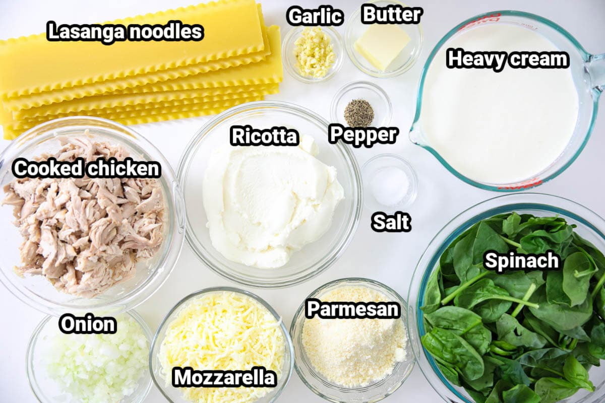 Ingredients for Chicken Alfredo Lasagna: lasagna noodles, garlic, butter, salt, pepper, heavy cream, ricotta, cooked chicken, onion, mozzarella, parmesan, and spinach. 