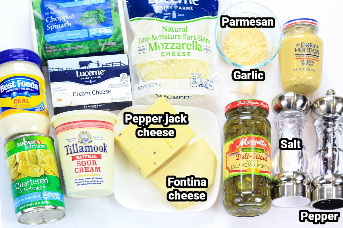 Ingredients for Hot Artichoke Dip, including mayo, sour cream, cream cheese, spinach, artichokes, jalapenos, Parmesan, pepper jack, fontina, and mozzarella cheese, garlic, dijon mustard, salt, and pepper.