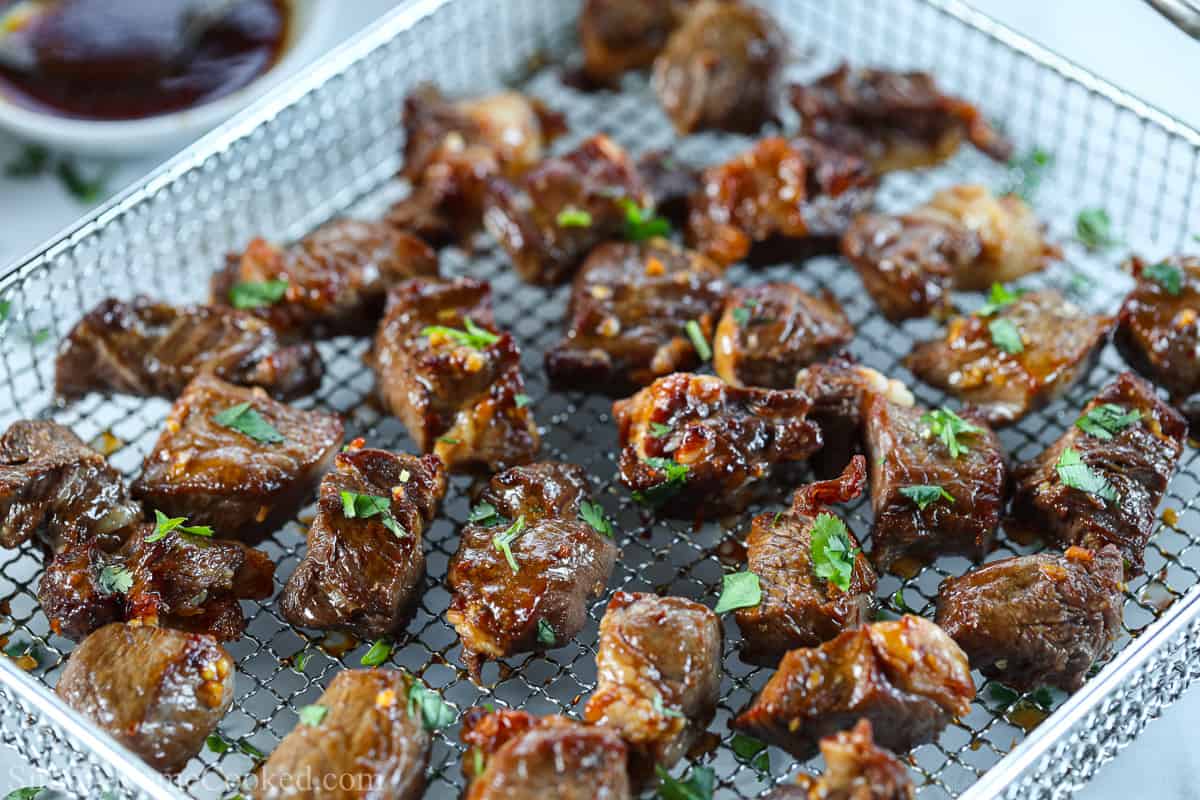 Air Fryer basket full of steak bites.