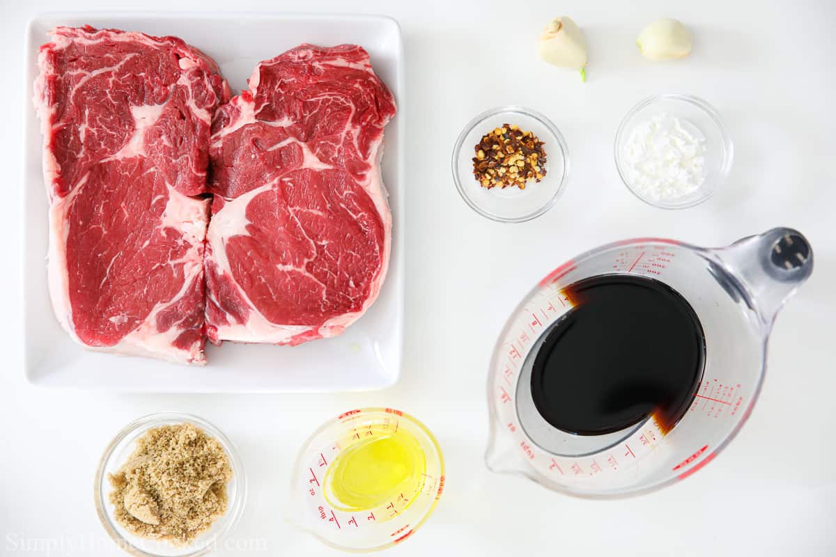 Ingredients for Juicy Air Fryer Steak Bites, including ribeye steak, brown sugar, soy sauce, corn starch, red pepper flakes, garlic, and salt.