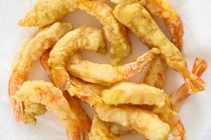 Shrimp tempura in a pile on a white background.
