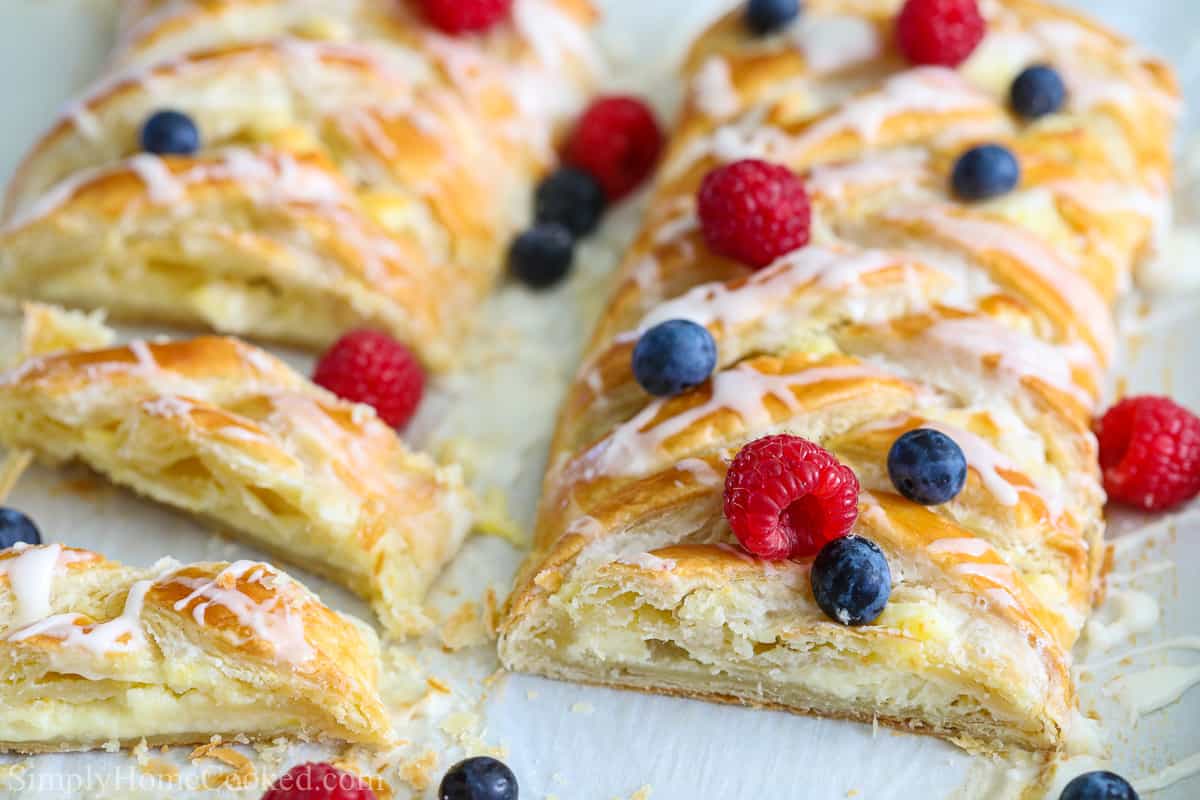 Two Cream Cheese Danishes sliced and covered with berries.