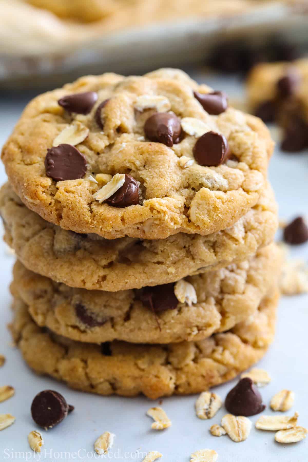 These Chewy Peanut Butter Oatmeal Cookies are soft & delicious. Chewy oats, nutty peanut butter & gooey chocolate chips make them so addictive. #chewpeanutbutteroatmealcookies #chewypboatmealcookies #chewyoatmealpeanutbuttercookies #chocolatechippeanutbutteroatmealcookies Stack of Chewy Peanut Butter Oatmeal Cookies with chocolate chips.