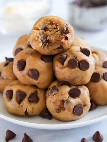 Closeup of a pile of balls of Edible Cookie Dough, the top one missing a bite.