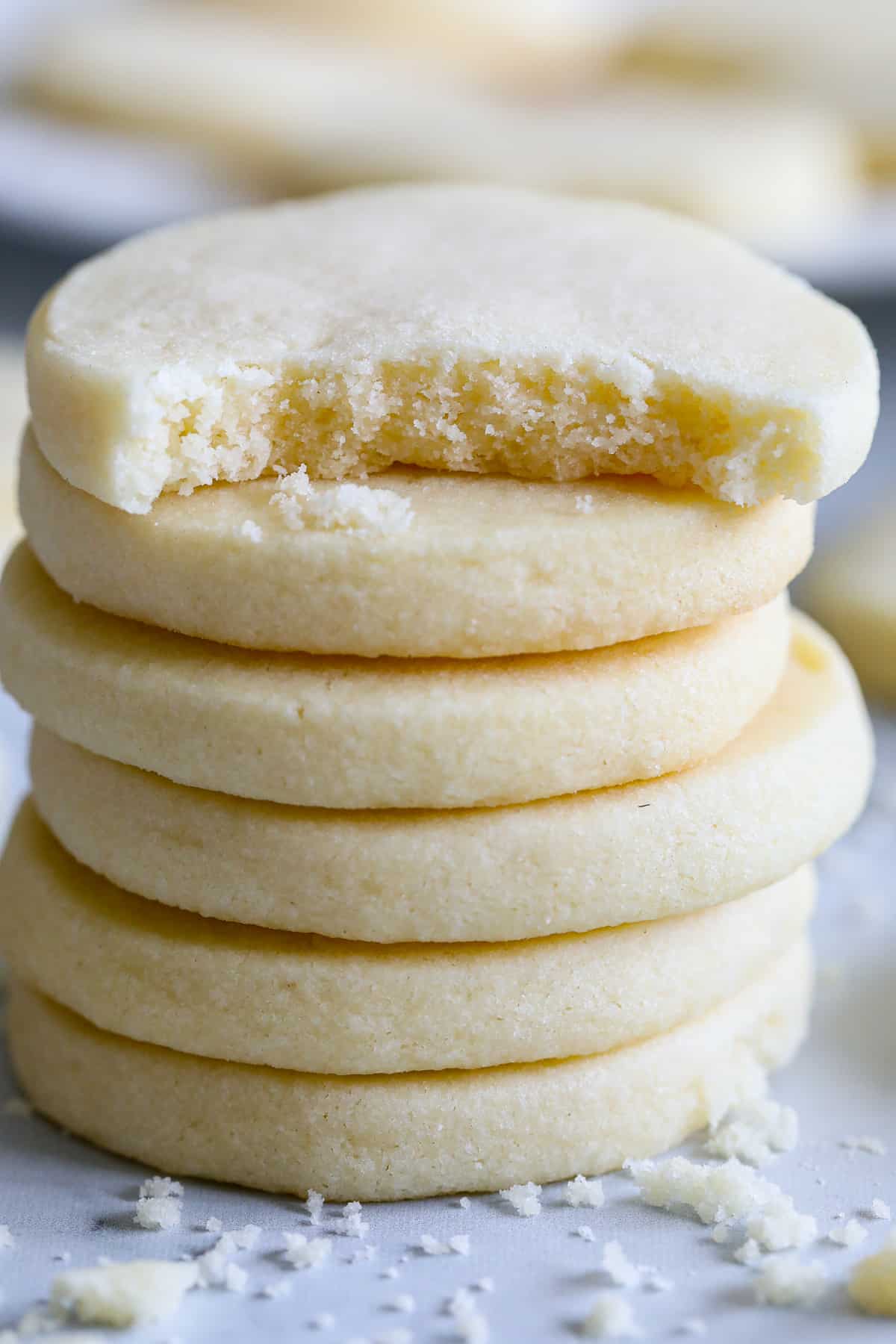 Crumbly, buttery, and delicious, these Classic Shortbread Cookies are just perfect for the holiday season. You can decorate them in so many ways! #shortbread #shortbreadcookies #classicshortbreadcookies #butteryshortbreadcookies Stack of Classic Shortbread Cookies with a bite taken out of the top one.