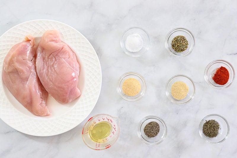 Ingredients for Juicy Air Fryer Chicken Breasts including boneless skinless chicken breasts, oil, garlic powder, onion powder, Italian seasoning, thyme, paprika, salt, and pepper.