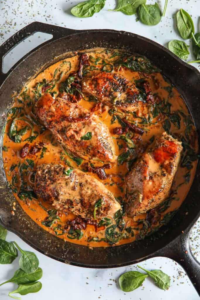 Overhead image of Creamy Tuscan Chicken in a cast iron skillet.