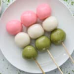 3 Hanami Dango on a white place with matcha powder next to it.