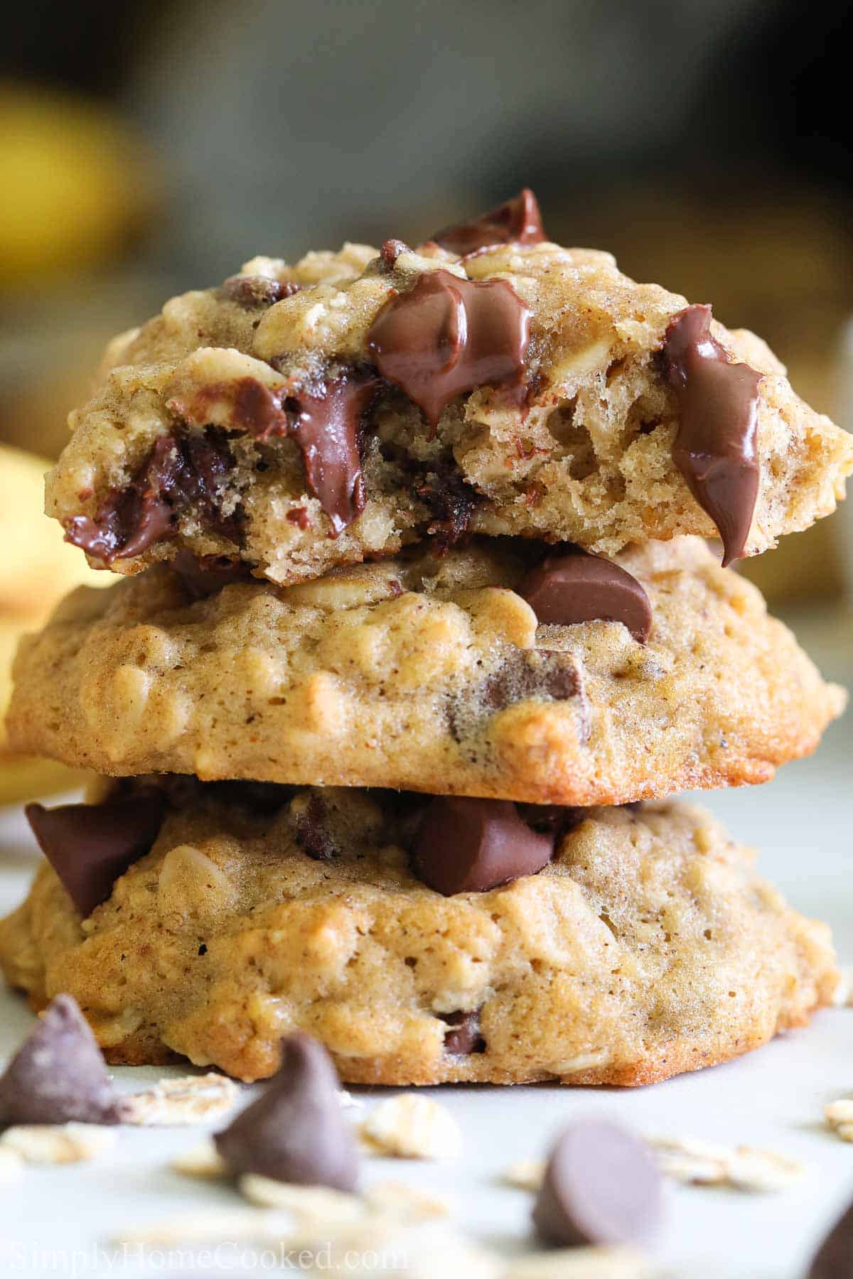 These Chewy Banana Oatmeal Cookies are so good. You have got to try this scrumptious cookie recipe that has the perfect level of chewiness. #chewyoatmealcookies #bananaoatmealcookies #chewybananaoatmealcookies #oatmealcookierecipe close up image of a stack of banana oatmeal chocolate chip cookies