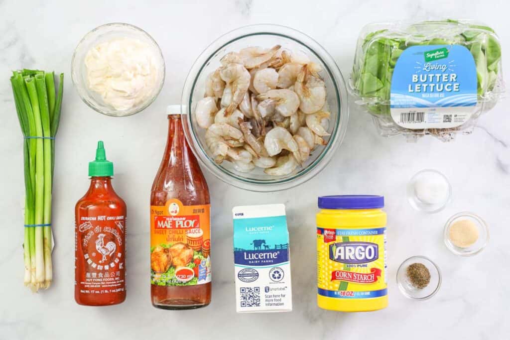 Ingredients for Bang Bang Shrimp recipe, including butter lettuce, green onions, shrimp, cornstarch, garlic powder, salt, pepper, buttermilk, sweet chili sauce, mayo, and Sriracha.