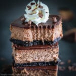 Stack of Chocolate Cheese Cake Bars with whipped cream on top