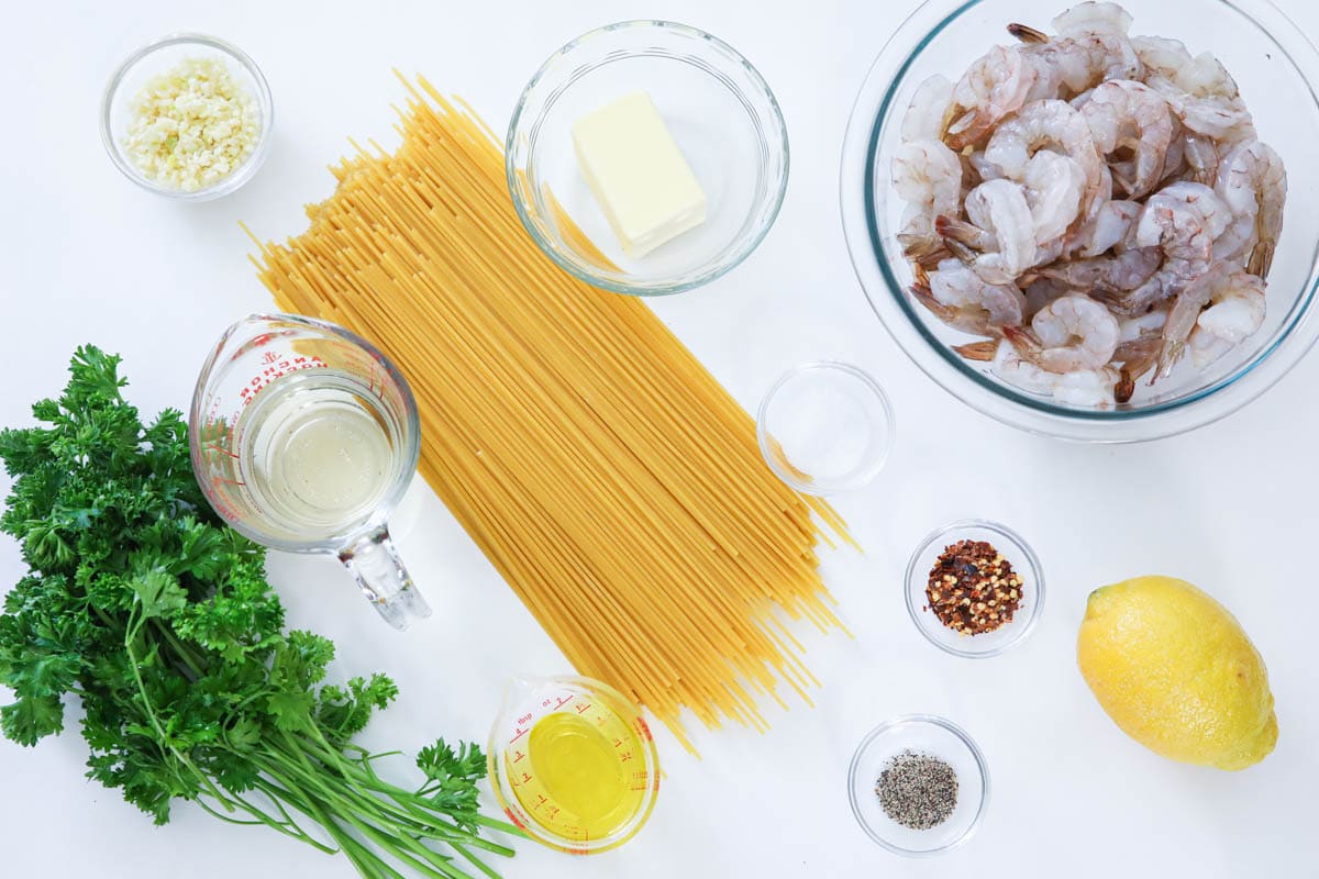Ingredients for Shrimp Scampi Pasta, including pasta, shrimp, butter, oil, parsley, salt, pepper, red pepper flakes, lemon juice, garlic, and white wine.