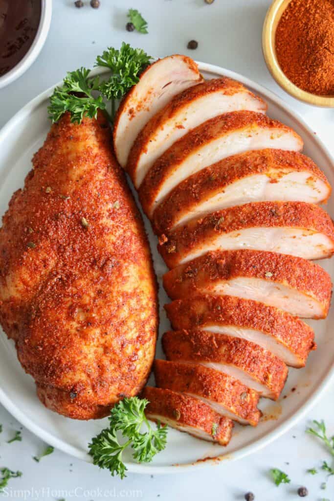 Smoked Chicken Breast sliced on a plate with a parsley garnish