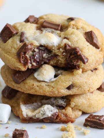 Verical image of S'mores Cookies stacked with a bite missing