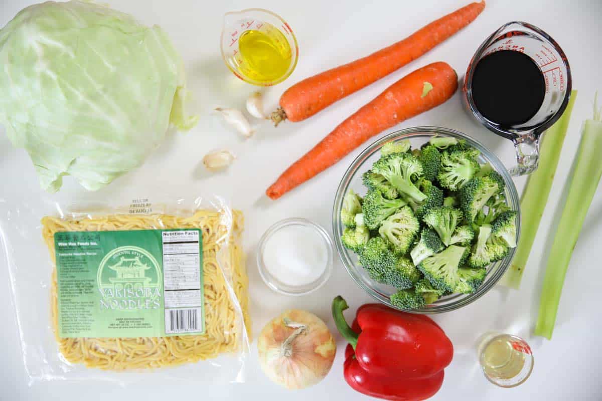 This delicious vegetable chow mein is loaded with stir-fried vegetables, thick yakisoba noddles, and an easy Asian sauce that takes this dish to the next level. #chowmein #yakisoba #asiannoodles #ramen #vegetablechowmein #stirfriednoodles Ingredients for Chow Mein, including Garlic cloves, Celery, Carrots, Onion, Cabbage, Broccoli, and Red bell pepper, rice vinegar, soy sauce, sugar, yakisoba noodles, and oil.
