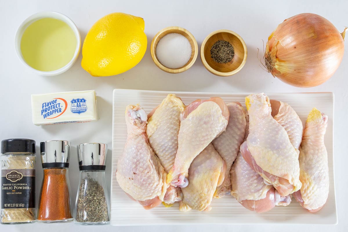 Ingredients for Baked Chicken Drumsticks, including chicken legs, onion, lemon, oil, butter, salt, pepper, thyme, paprika, and garlic powder.