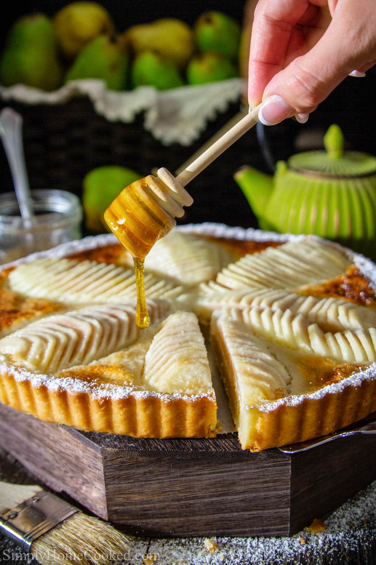 Vertical image of honey drizzling on Pear Tart.