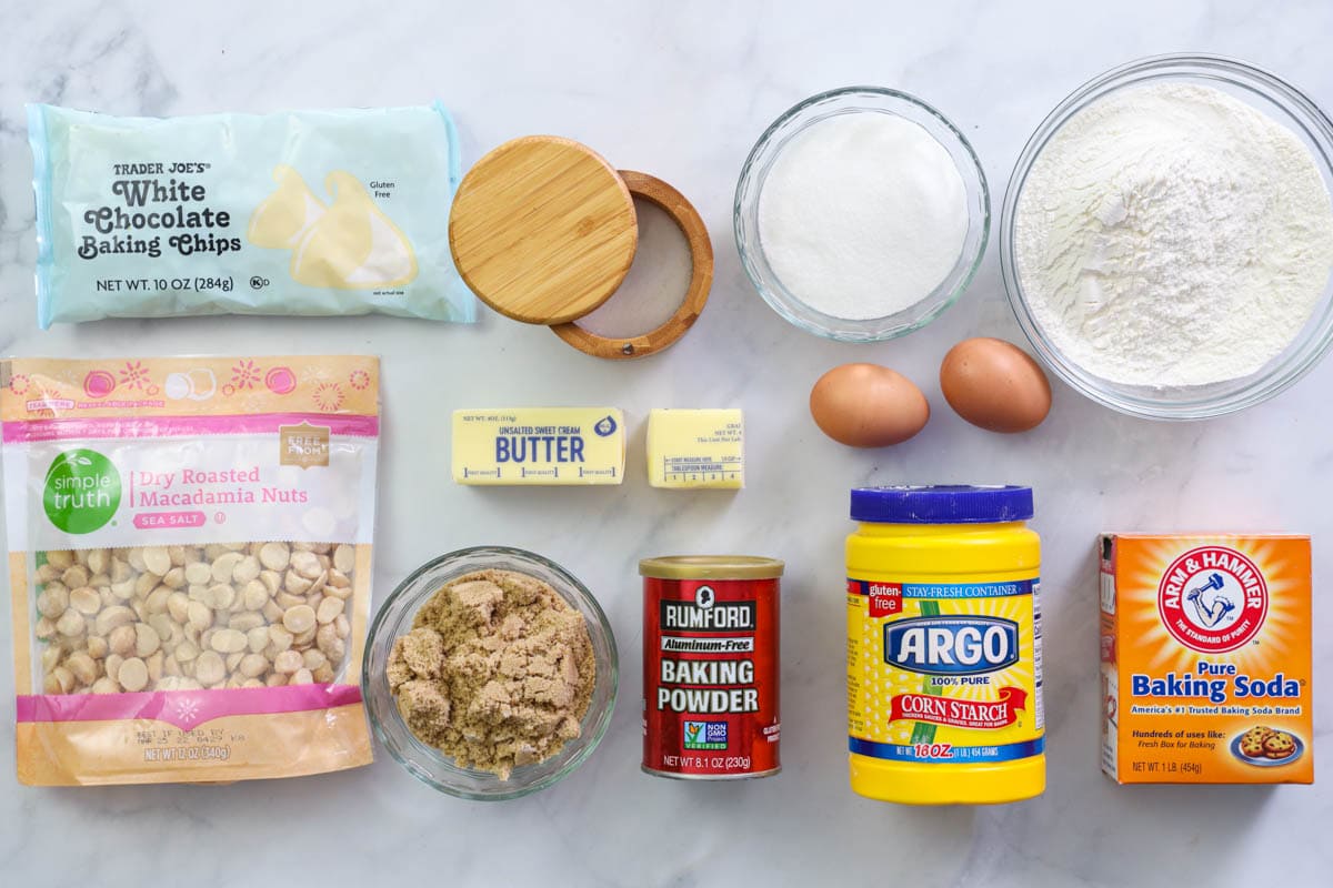 Ingredients for White Chocolate Macadamia Nut Cookies, including flour, baking soda ,baking powder, salt, cornstarch, sugar, brown sugar, eggs, butter, macadamia nuts, and white chocolate chips. #whitechocolatecookies #whitechocolatechipcookies #macadamianutcookies #chocolatemacadamianutcookies 