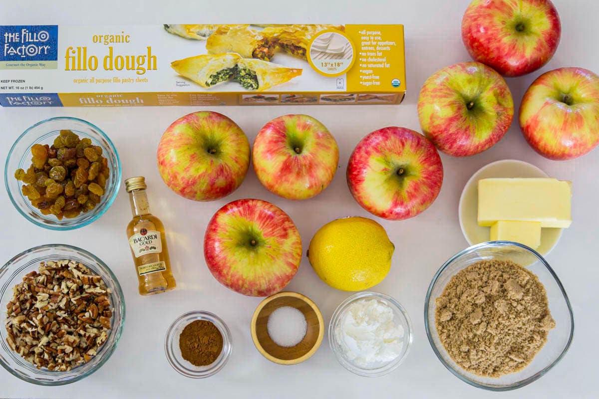 Ingredients for Apple Strudel, including honeycrisp apples, phyllo dough, rum, raisins, pecans, brown sugar, salt, cinnamon, butter, lemon, and cornstarch.