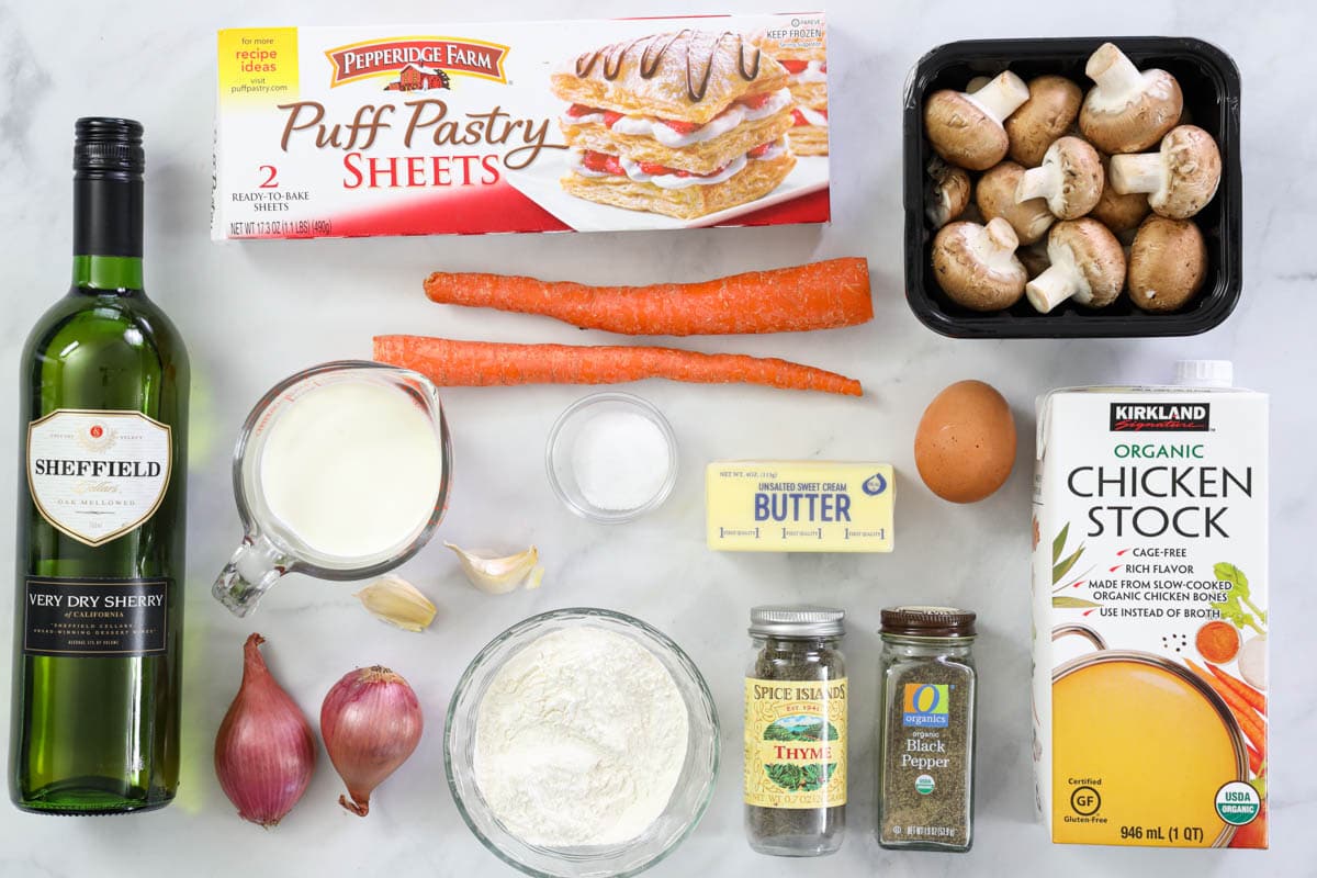 Ingredients for Cream of Mushroom Soup, including puff pastry, mushrooms, shallots, carrots, garlic, chicken broth, butter, egg, sherry, heavy cream, flour, salt, pepper, and thyme.