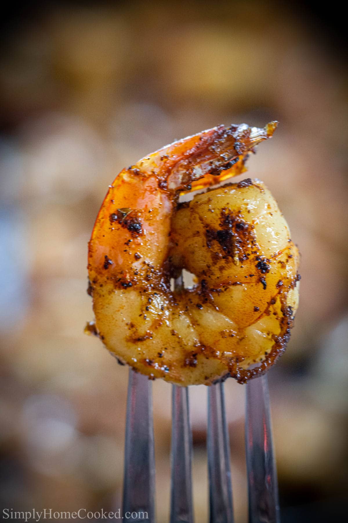 Are you looking for an easy and quick recipe for blackened shrimp? These shrimp are packed with flavor, juicy, and easy to make. #makeaheadshrimp #mealprepshrimp #lowcarbshrimprecipe #healthyshrimprecipe Vertical image of a close up of Cajun Shrimp on a fork