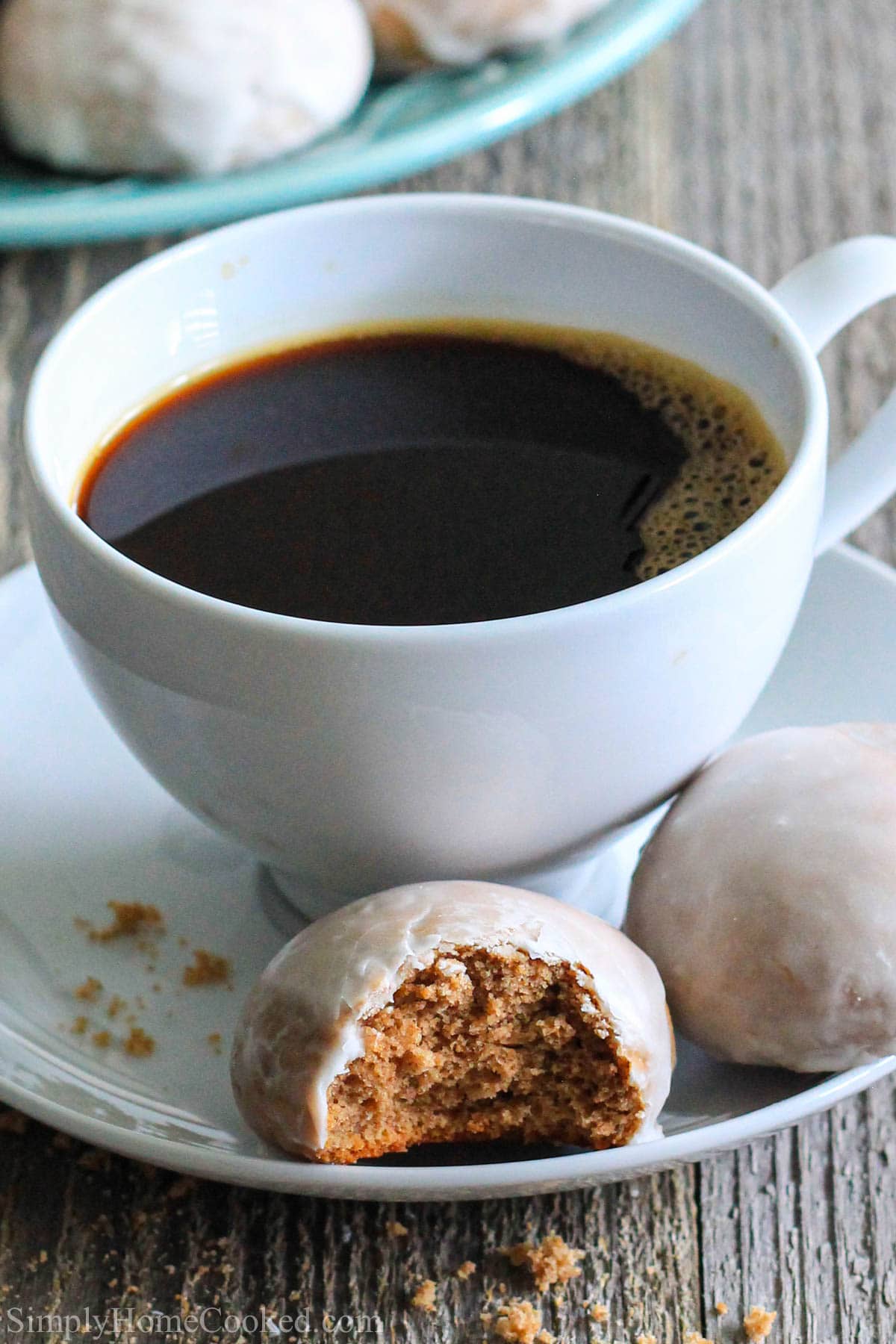 This Traditional Russian Pryaniki recipe with an easy mint glaze is a perfect tea or coffee accompaniment that comes together easily. #pryaniki #russiancookies #teacookies #ryecookies #russianteacookies #galzedcookies Vertical image of Russian Pryaniki with Mint Glaze on a white plate with a cup of hot coffee