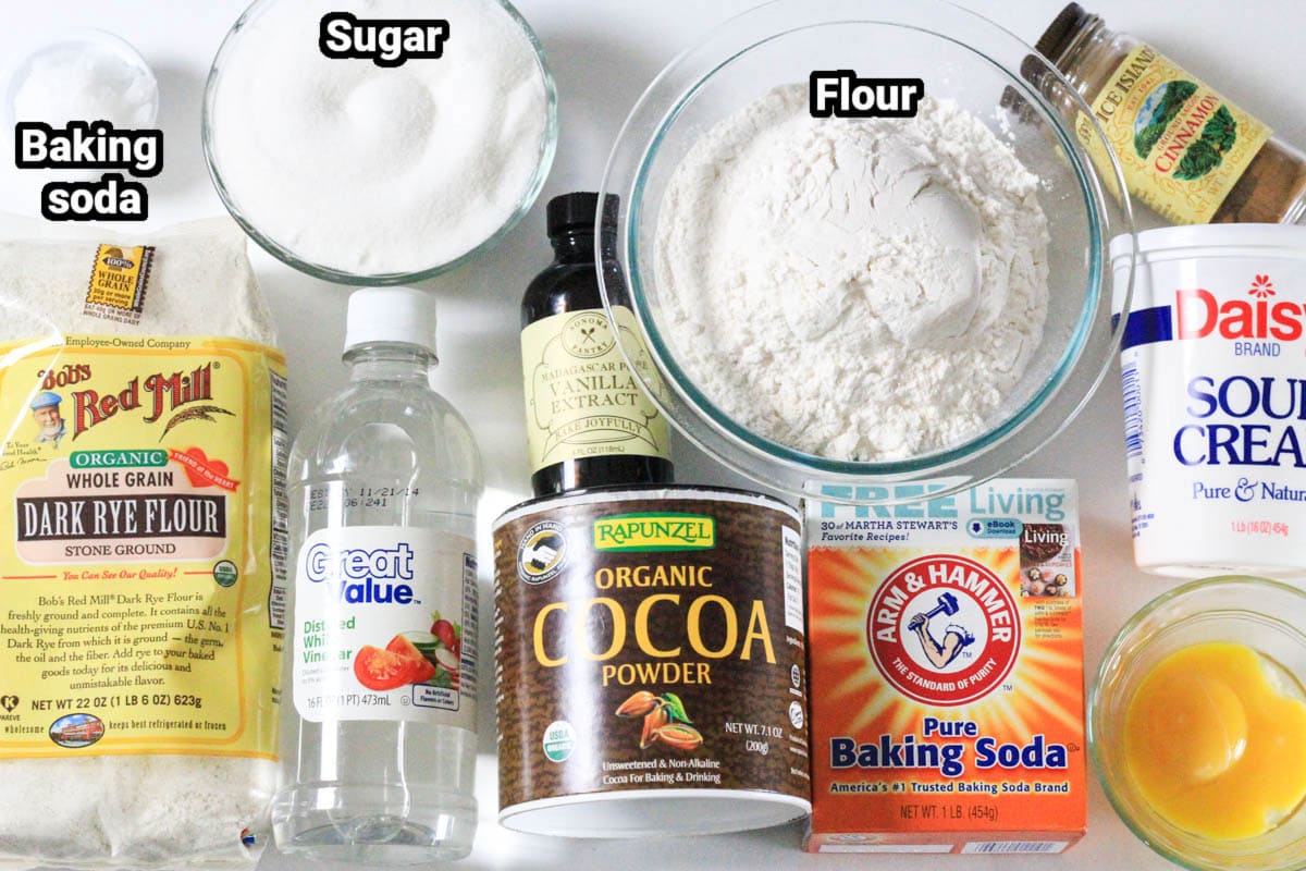 This Traditional Russian Pryaniki recipe with an easy mint glaze is a perfect tea or coffee accompaniment that comes together easily. #pryaniki #russiancookies #teacookies #ryecookies #russianteacookies #galzedcookies Ingredients for Russian Pryaniki with Mint Glaze, including flour, rye flour, sugar, baking soda, vinegar, vanilla, mint extract, cocoa powder, cinnamon, sour cream, and egg yolk.