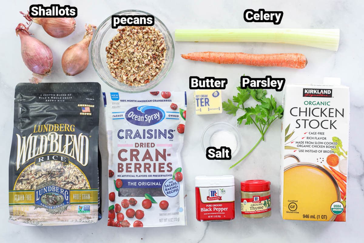 Ingredients for Wild Rice, including wild rice blend, cranberries, chicken stock, shallots, celery, carrot, butter, pecans, thyme, salt, pepper, and parsley.