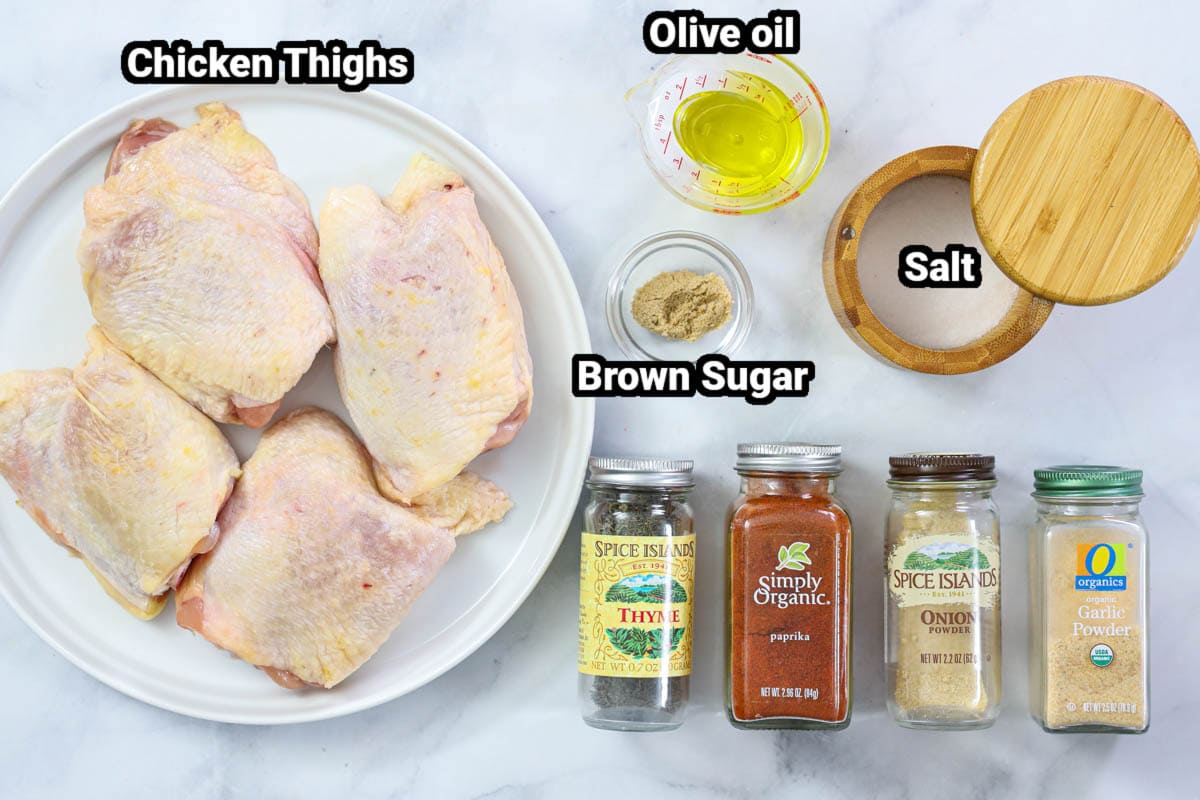 Ingredients for Air Fryer Chicken Thighs, including bone-in chicken thighs, olive oil, salt, brown sugar, garlic powder, onion powder, paprika, and thyme.