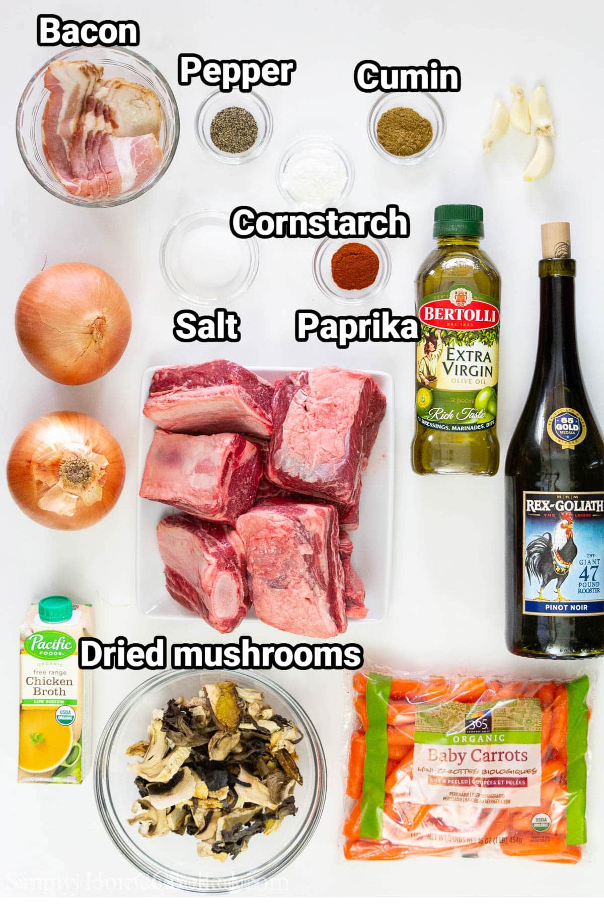 Ingredients for Braised Beef Short Ribs, including short ribs, oil, red wine, onion, garlic, cornstarch, cumin, paprika, salt, pepper, dried mushrooms, carrots, and chicken broth.