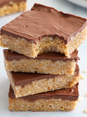 Vertical image of a stack of Scotcheroos, the top one missing a bite