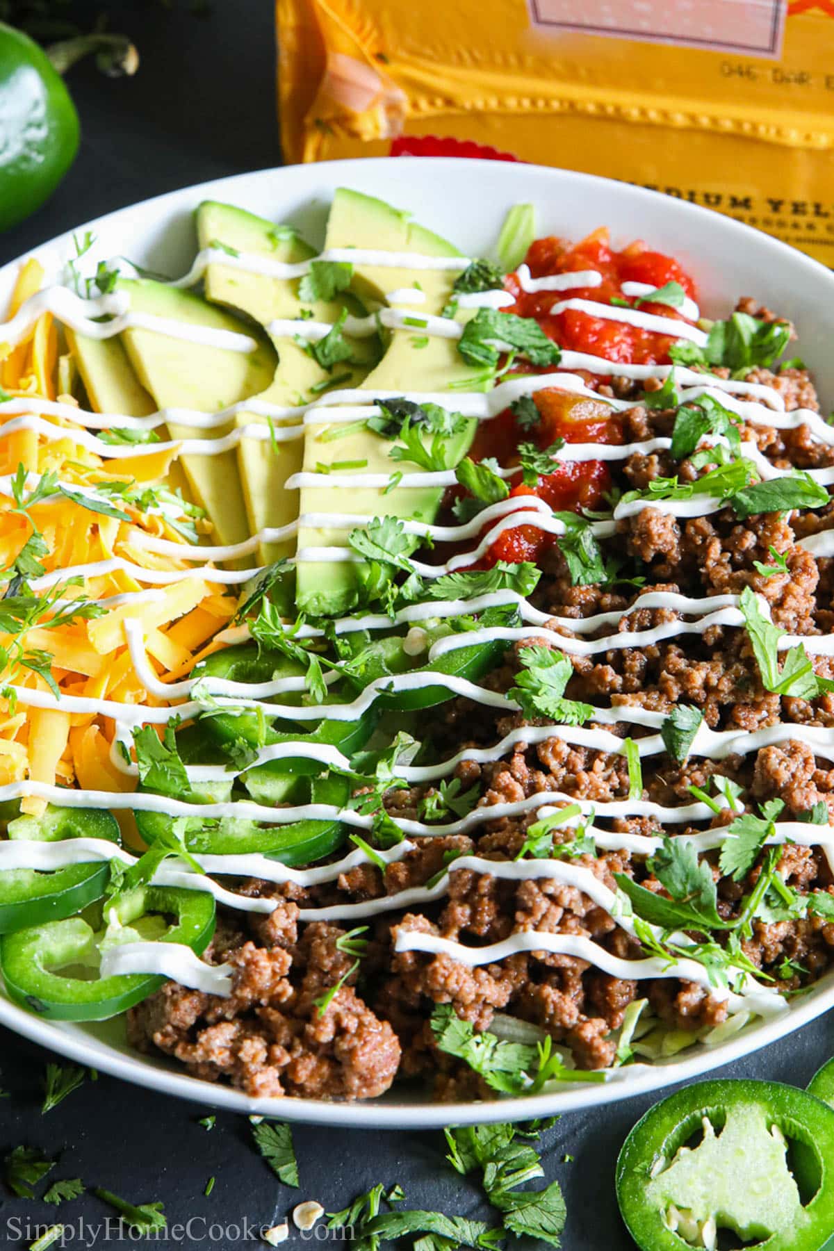 This easy taco salad recipe is packed with flavor and super easy to whip up. Its are also a low-carb and high protein meal that is perfect for meal prepping! #tacobowls #tacobowl #tacorecipe #besttacos #beeftaco #tacosalad Taco Salad Recipe in a white bowl