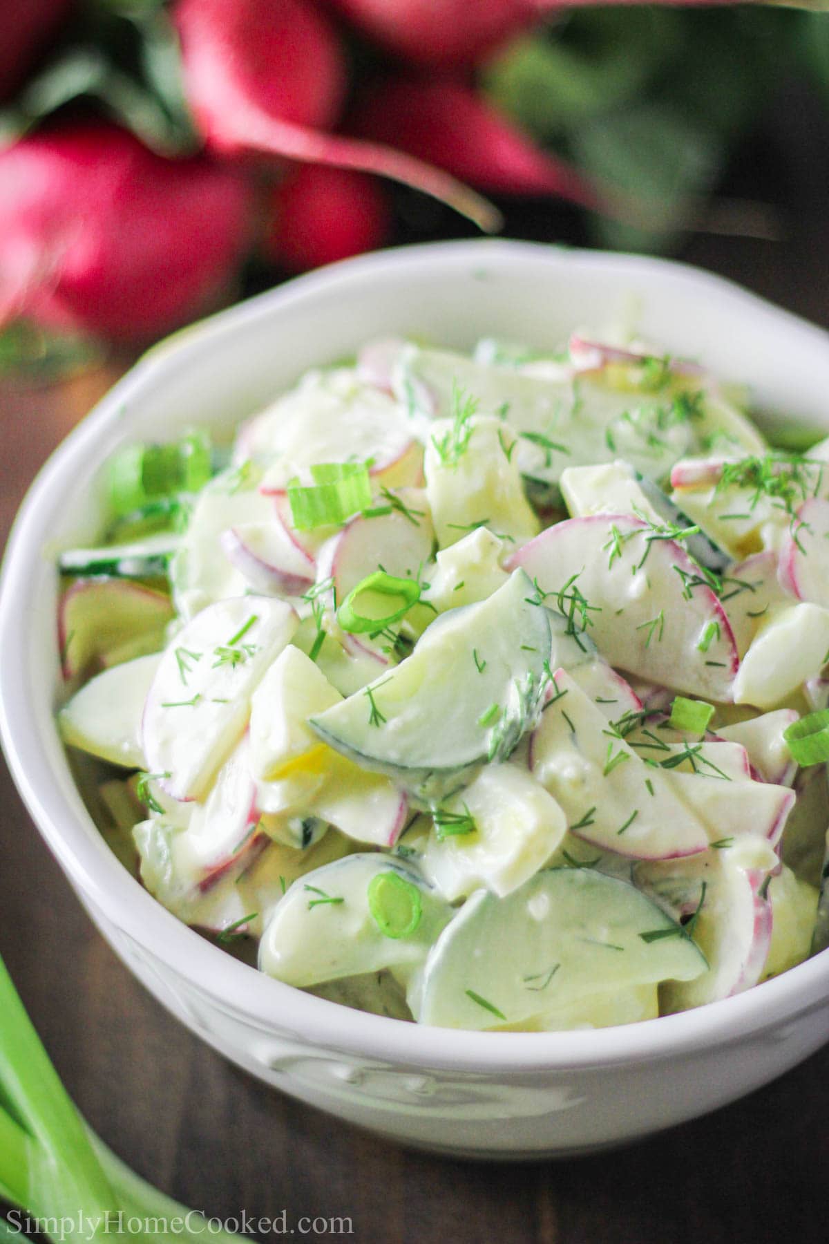 This refreshing and creamy Cucumber Egg Radish Salad Recipe is a unique option to serve alone or as a side at your next summer barbecue. #radishsalad #cucumbersalad #summersalad #eggsalad #creamysalad #crunchysalad Cucumber Radish Salad in a white bowl