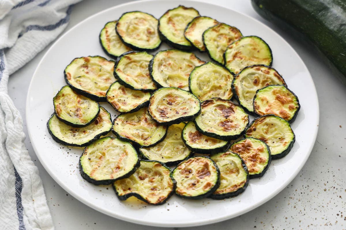 Air Fryer Zucchini layered on a white plate 
